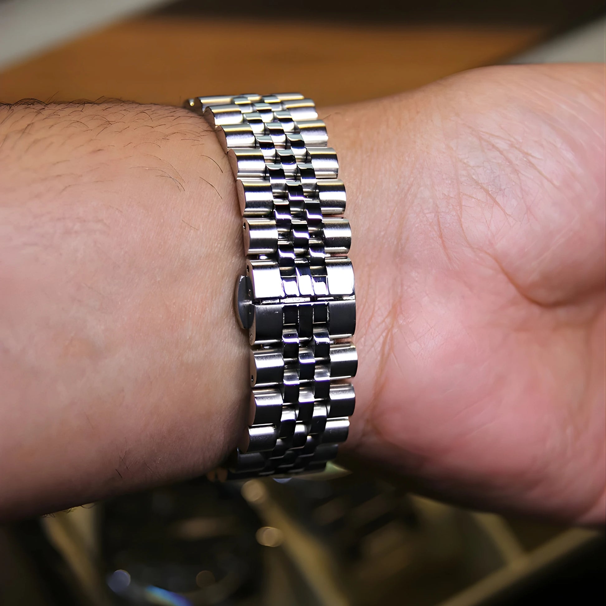Close-up of a person's wrist wearing a silver metal watch.