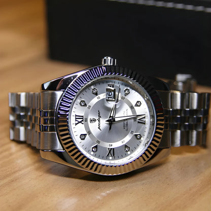 Silver watch with a detailed face on a wooden surface